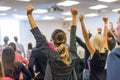 Participants of interactive motivational speech feeling empowered and motivated, hands raised high in the air. Royalty Free Stock Photo