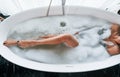 Particle view of legs. Beautiful young woman have free time at home in the bath Royalty Free Stock Photo