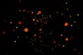 Particles of burning embers fly and glow isolated in the night sky. Bright yellow sparks on a black background yellow bright