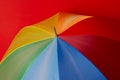 Particoloured umbrella on red background