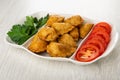 Partitioned dish with patties, leaves of parsley, tomato on wooden table Royalty Free Stock Photo