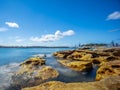 Sydney Harbour with nice rocks in the foreground the soft waves crashing on the shore NSW Australia Royalty Free Stock Photo