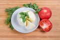 Partly cut soft cheese ball on saucer, tomatoes and greens Royalty Free Stock Photo