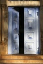 Partly open blue entrance door with ornaments in warm afternoon light, Catas Altas, Minas Gerais, Brazil