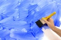 Man painting wall, holding paintbrush, blue paint, copy space Royalty Free Stock Photo