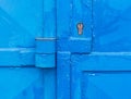 Partly rusted locked industrial door with scratched metal latch