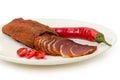 Partly sliced dry-cured pork tenderloin and chili on dish Royalty Free Stock Photo