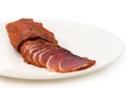 Partly sliced dry-cured pork tenderloin on dish, close-up Royalty Free Stock Photo