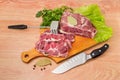 Partly sliced pork neck on cutting board, meat tenderizer, knife Royalty Free Stock Photo