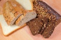 Partly sliced various bread on wooden cutting board, top view Royalty Free Stock Photo