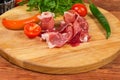 Partly twisted thin slices of jamon on round cutting board