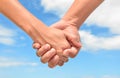 Partner hand between a man and a woman on blue sky background