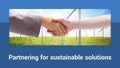 Partnering for sustainable solutions text with diverse female handshake and wind turbines in field Royalty Free Stock Photo