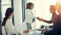 Partnering together to achieve their greatest success yet. businesspeople shaking hands during a meeting in an office.