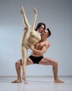 Partners acrobats posing against a white wall. Young duet of ballet dancers perform support with twine in the studio. A