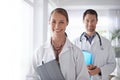 Partners in health. Portrait of two young doctors standing in a hospital corridor. Royalty Free Stock Photo