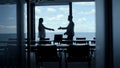 Partners silhouette shaking hands at marina view office. Manager greeting client