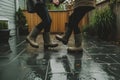 partners in waterproof boots do a jitterbug on a wet patio Royalty Free Stock Photo