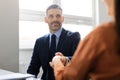 Partnership concept. Man entrepreneur giving hand for handshake to female in office, businessman offering cooperation Royalty Free Stock Photo