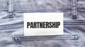 PARTNERSHIP words on a white paper stuck out from jeans pocket. Business concept