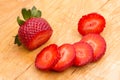 Parts of strawberry on wooden cutting board