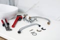 Parts of water tap and wrenches on countertop in bathroom Royalty Free Stock Photo