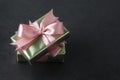 Party, birthday present in golden box with pink bow on black background. Top view or flat lay. Copy space Royalty Free Stock Photo