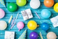 Party birthday table. Colorful balloons, gifts, confetti and carnival cap on blue table top view. Holiday supply. Royalty Free Stock Photo