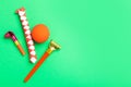 Party blowers, clown nose and chinese finger trap on green background, flat lay. Space for text Royalty Free Stock Photo