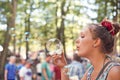 Party, bubbles and music with woman at festival in forest for celebration, summer and performance. Carnival, culture and Royalty Free Stock Photo