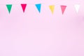 Party colorful flags on pink background, happy birthday composition or border, horizontal, copy space, top view Royalty Free Stock Photo