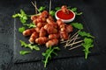 Party finger food pigs in blankets on toothpicks with ketchup sauce and wild rocket leaves Royalty Free Stock Photo