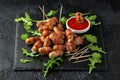 Party finger food pigs in blankets on toothpicks with ketchup sauce and wild rocket leaves Royalty Free Stock Photo