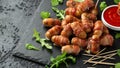 Party finger food pigs in blankets on toothpicks with ketchup sauce and wild rocket leaves Royalty Free Stock Photo