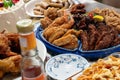 Party foods on the table with fried chicken, spaghetti, spring rolls and chili sauce.