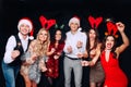 Party with friends. They love Christmas. Group of cheerful young people carrying sparklers and champagne flutes dancing Royalty Free Stock Photo