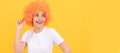 Party fun wig. cheerful funny girl with fancy look wearing orange hair wig on yellow background, cool. Woman isolated