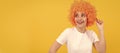 Party fun wig. cheerful funny girl with fancy look wearing orange hair wig on yellow background, cool. Woman isolated