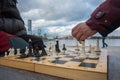 Party game white and black chess pieces on a wooden board against the backdrop of a city and sky with clouds Royalty Free Stock Photo