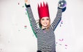 Party girl in colorful spotlights and confetti smiling on white background celebrating brightful event, wears stripped Royalty Free Stock Photo