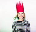 Party girl in colorful spotlights and confetti smiling on white background celebrating brightful event, wears stripped Royalty Free Stock Photo