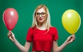 Party Girl in Fashionable Glasses is Grimacing and Looking at the Camera Holding Yellow and Red Air Balloons in the