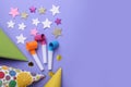 Party hats, blowers and confetti for birthday party on violet background, flat lay. Space for text Royalty Free Stock Photo
