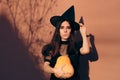 Halloween Woman in Witch Costume Holding Pumpkin