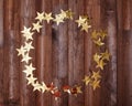 Party Mockup Round Gold Stars Frame on Dark Wood. Christmas Shiny Golden Tinsel for Card Design with Copy Space for Text Royalty Free Stock Photo
