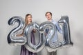 Party, people and new year holidays concept - woman and man celebrating new years eve 2021