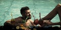 Party at the pool. Cocktail and bearded man in pool. Royalty Free Stock Photo