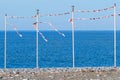 Party or season of vacations is over - an empty sea beach with pillars for festive flags.