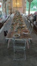 long table set in shabby chic style with plates, flowers and chairs Royalty Free Stock Photo