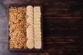 Party snacks, box with cookies, crackers and mini salted pretzels on a dark wooden background